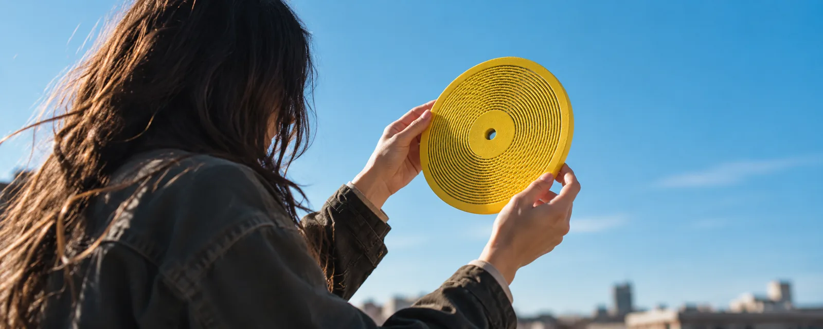 A fan holding a yellow Kräftsound disc up to the sky